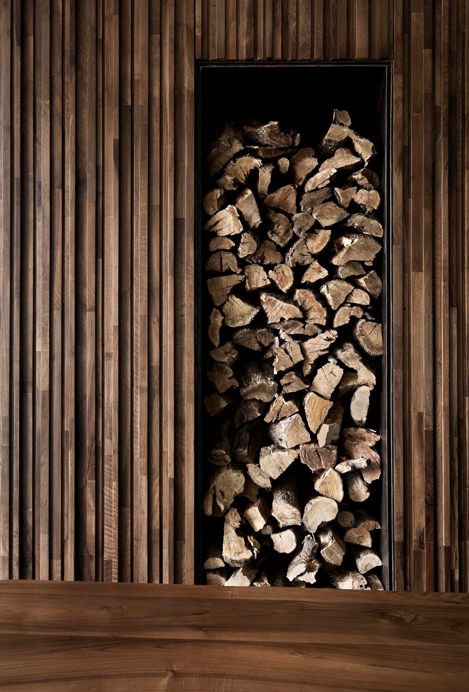 Firewood stacked in a timber niche at Villa E