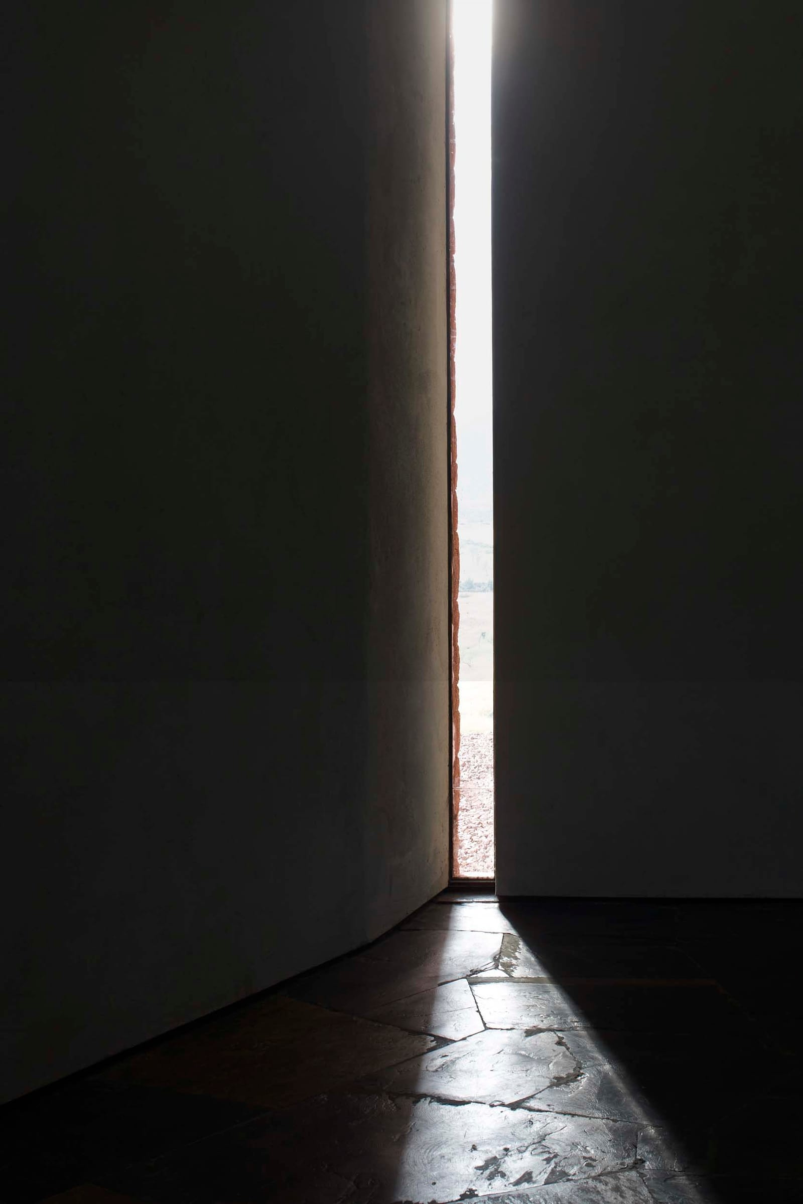 Vertical slit of light through a wall at Villa E