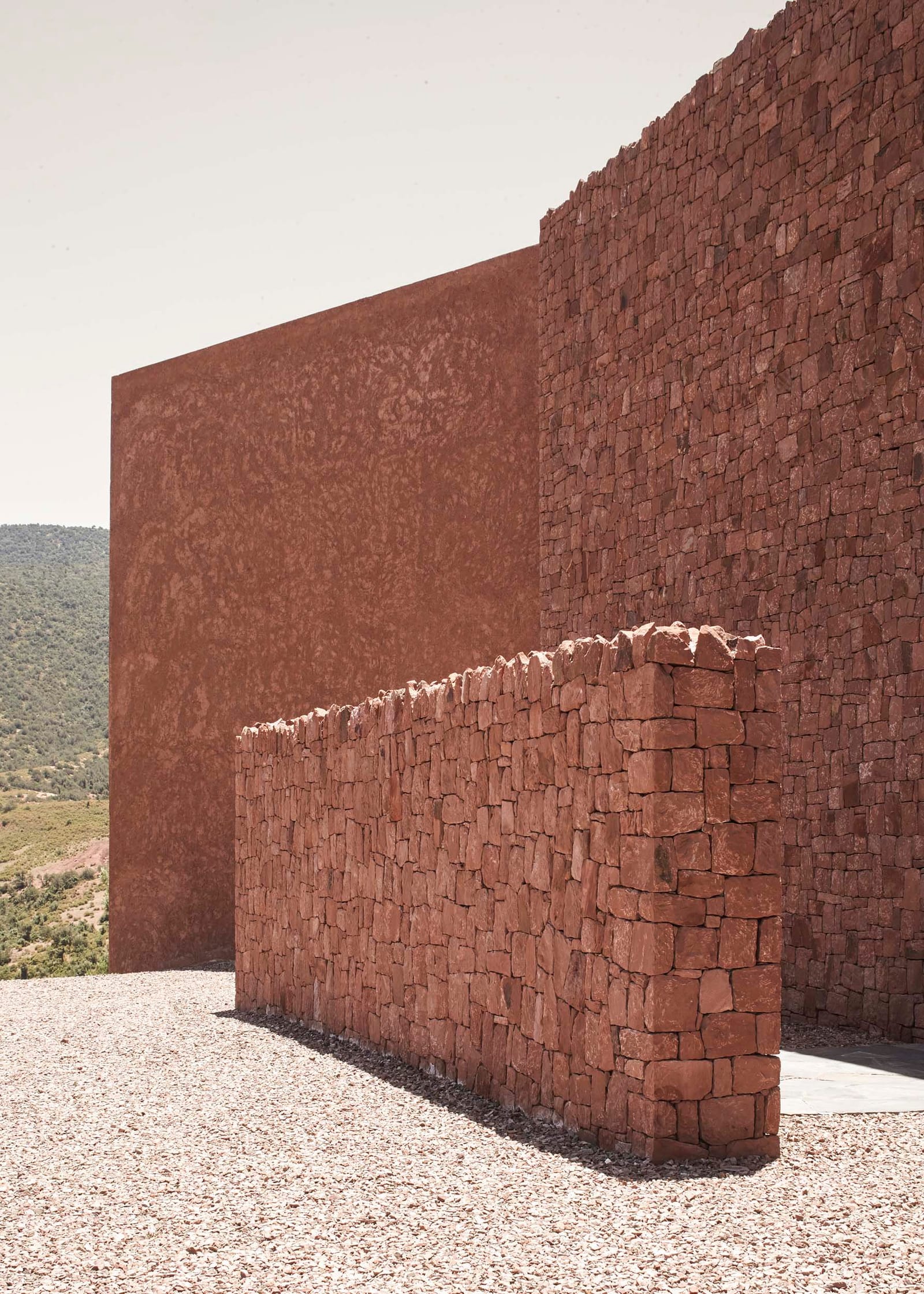 Hand-laid red stone walls at Villa E