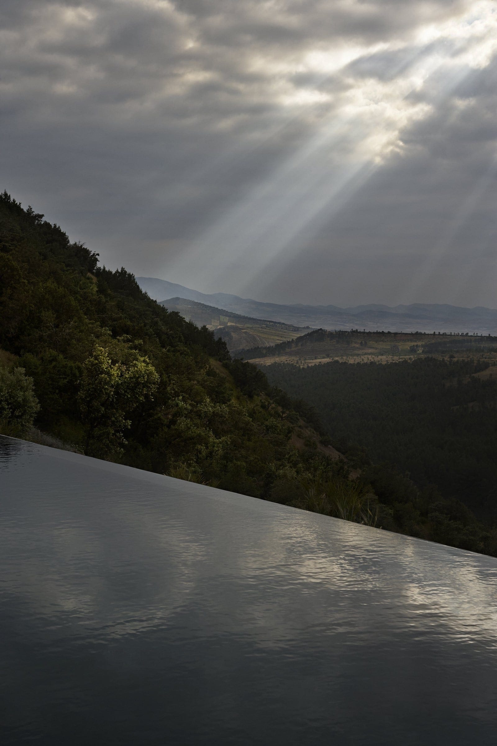 Infinity pool and shafts of light over the valley, Villa E
